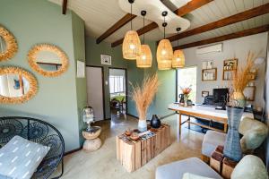 KwaNompondo犀牛岭野生山林小屋的客厅设有绿色的墙壁和桌椅