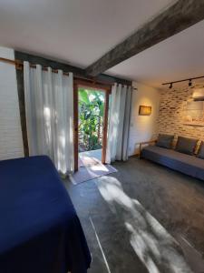 马劳Estudio Lirios seu cantinho ecológico na natureza的客房设有床、沙发和窗户。