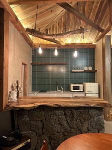 西归浦市Yonguk House的厨房配有石制柜台和微波炉。