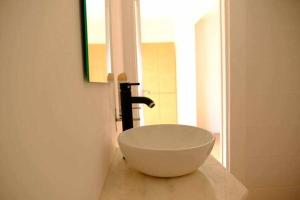 AroeiraSurfie Surf Beach e Adventure的浴室内一个位于柜台上的白色碗水槽