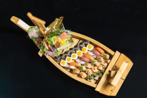 罗安达EPIC SANA罗安达酒店的木船,桌上放满了寿司和鸡蛋