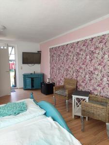 布雷格海滨酒店的一间卧室配有一张床和粉红色的花卉墙