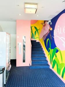 巴塞尔BALEGRA City Hotel Basel Contactless Self Check-in的走廊上设有蓝色地毯和彩色墙壁