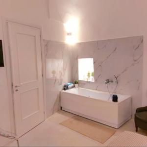 塔维亚诺Corte Petricore的白色的浴室设有浴缸和窗户。