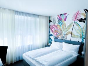 巴塞尔BALEGRA City Hotel Basel Contactless Self Check-in的一间卧室配有一张带花卉墙壁的床