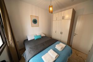 博德鲁姆Ilya Apart 1的一间小卧室,配有蓝色的床和白色毛巾