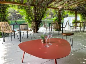 尼姆宜必思尼姆西部酒店 - A9 的一张红色桌子和两杯酒杯