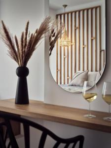 拉加纳斯Cassiopeia Rooms & Suites的一张带镜子的桌子和两杯葡萄酒