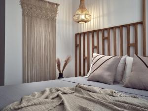 拉加纳斯Cassiopeia Rooms & Suites的一间卧室配有一张带毯子和吊灯的床。