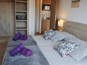 罗列特海岸Marina Beach Apartaments的一间卧室配有两张带紫色枕头的床