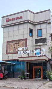 班达亚齐Hotel Meurah Mulia Syariah的建筑前方有标志的酒店