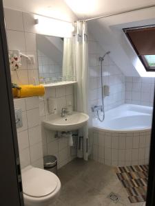 尼赖吉哈佐Svájci Lak Panzió的浴室配有卫生间、盥洗盆和浴缸。