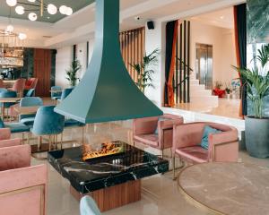 特里波利斯AKROTHEA suites & lounge的大堂设有壁炉、椅子和桌子。