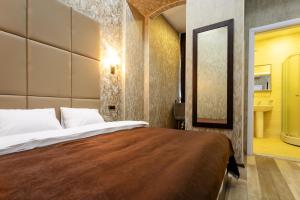 巴库Gardenian Hotel Baku的一间卧室配有一张大床和镜子