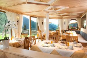 塞尔瓦迪加尔代纳山谷Hotel Garni Aghel的用餐室设有桌椅和窗户。