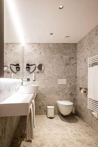 维也纳新城Hotel Le Parc的一间带两个盥洗盆和卫生间的浴室