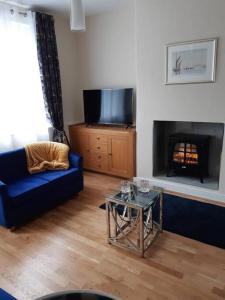 康威Charming Mid Terrace Cottage的客厅设有蓝色的沙发和壁炉