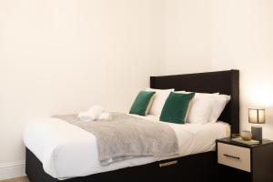 沃尔斯雷Apartment 4 - Beautiful 1 Bedroom Apartment Near Manchester的一间卧室配有一张带绿色和白色枕头的大床