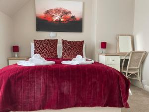 滨海克拉克顿石岩酒店的一间卧室配有一张带两条毛巾的紫色床