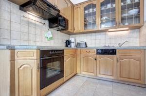 黑灵斯多夫Villa Minheim - FeWo 04的厨房配有木制橱柜和黑色用具