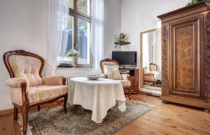 黑灵斯多夫Villa Minheim - FeWo 04的客厅配有桌子、两把椅子和电视