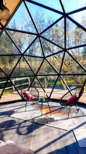 萨拉茨格里瓦Glamping dome tent BUUDA的窗户客房内的两把椅子和一张桌子