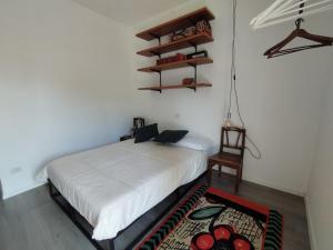 托尔博莱Casa di Nin的卧室配有白色的床和椅子