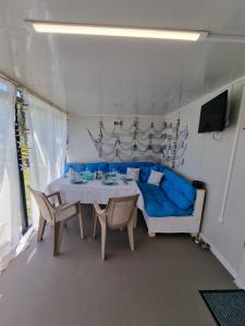 希典Бунгало РАФИ в къмпинг Атлиман - гр. Китен的一间配备有蓝色沙发和一张桌子的用餐室