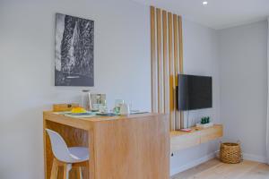 丰沙尔Casal da Penha Apartments的客房设有一张桌子、一把椅子和一台电视。