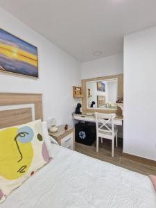 阿格特Alojamiento Agaete Pueblo Nº7的一间卧室配有一张床和一张桌子及椅子