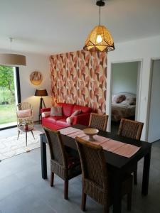 乌尔坦Charmante Maison neuve au Lac d'Hourtin的客厅配有桌子和红色沙发