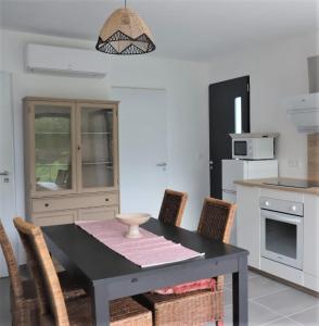 乌尔坦Charmante Maison neuve au Lac d'Hourtin的厨房配有黑色的桌子和椅子