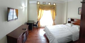 巴东Flamboyan House的一间卧室配有一张床、一个梳妆台和一扇窗户。