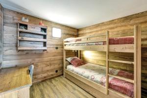 布里昂松LA FERME de BELLINE Chalets ou Gîtes & SPA的小屋内设有一间带两张双层床的卧室