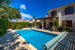 库克里亚3 bedroom Villa Athina with private pool and golf views, Aphrodite Hills Resort的房屋前的游泳池