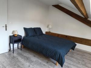 CamuracGîte dans les Pyrénées的一间卧室配有一张带蓝色毯子和一张桌子的床。