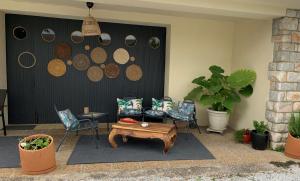 BramVilla Cattus location maison的一个带椅子和茶几及墙壁的庭院