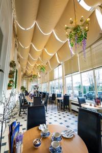 巴克斯顿巴克斯顿皇宫酒店及Spa的一间带桌椅和大型天花板的餐厅