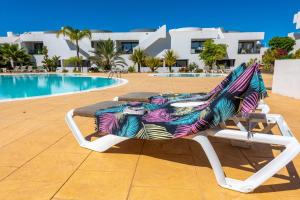 维拉韦德Casilla de Costa的游泳池旁的躺椅,带五颜六色的毯子
