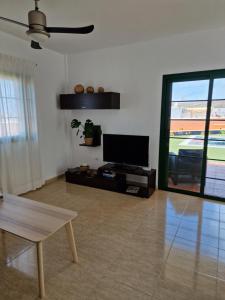 塔拉哈勒赫TaraVilla的客厅配有平面电视和桌子。