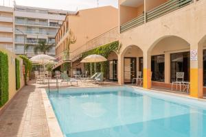 蒙蒂戈杜Casablanca Unique Hotel的一座带椅子和遮阳伞的游泳池