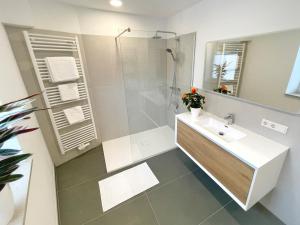 施塔特韦伦Haus Wehlen的白色的浴室设有水槽和淋浴。