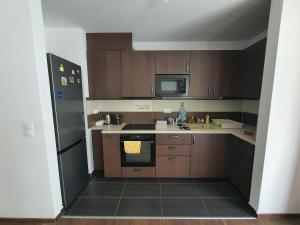 布达佩斯Park West Apartment - Free Parking的厨房配有木制橱柜和黑色冰箱。