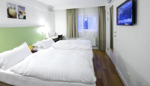默恩达尔默恩达尔早安酒店的两张床铺,位于酒店客房,墙上配有电视