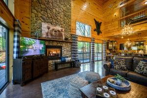 布罗肯鲍Hickory Bear - Cabin surrounded by pines, Sleeps 10, Hot Tub, Fire Pit, Arcade, Foosball Table & Deck Slide的一间带电视和石墙的客厅