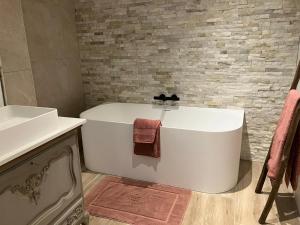LubbeekOns Hofke的浴室配有白色浴缸和水槽