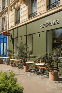 巴黎Hotel Orphée - Orso Hotels的大楼前的商店,有桌椅