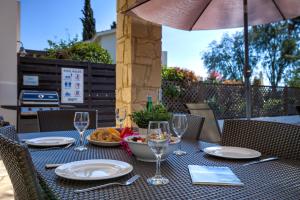 库克里亚2 bedroom Villa Proteus with private pool, Aphrodite Hills Resort的酒杯桌子和一碗食物
