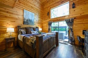 布罗肯鲍Hickory Bear - Cabin surrounded by pines, Sleeps 10, Hot Tub, Fire Pit, Arcade, Foosball Table & Deck Slide的小木屋内一间卧室,配有一张床