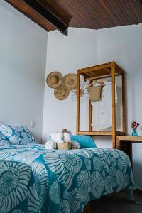 费尔南多 - 迪诺罗尼亚Pousada Sette Mares的卧室配有蓝色和白色的床和镜子